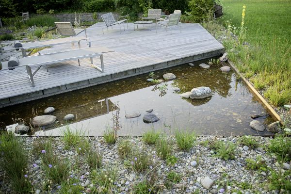 Sitzplatz und Teich einer biologischen Gartengestaltung.